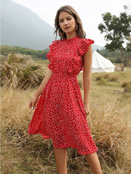 Robe fleurie rouge portée par une femme debout dans un champs de blé