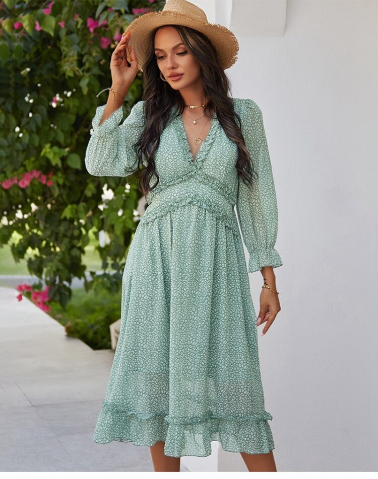 Femme portant une robe fleurie verte mi-longue avec un chapeau en osier sur la tête